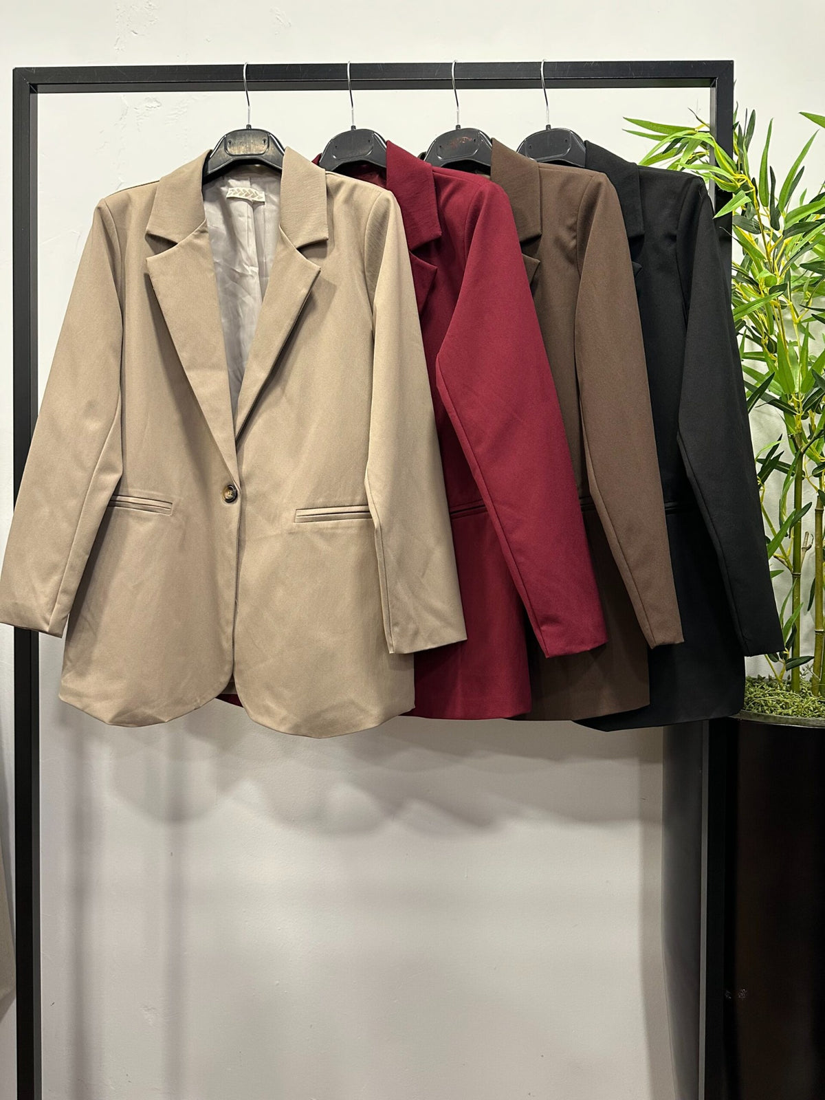 Chastar blazer met reverskraag in Beige, Bordeaux, Bruin en Zwart aan een kledingrek, vooraanzicht