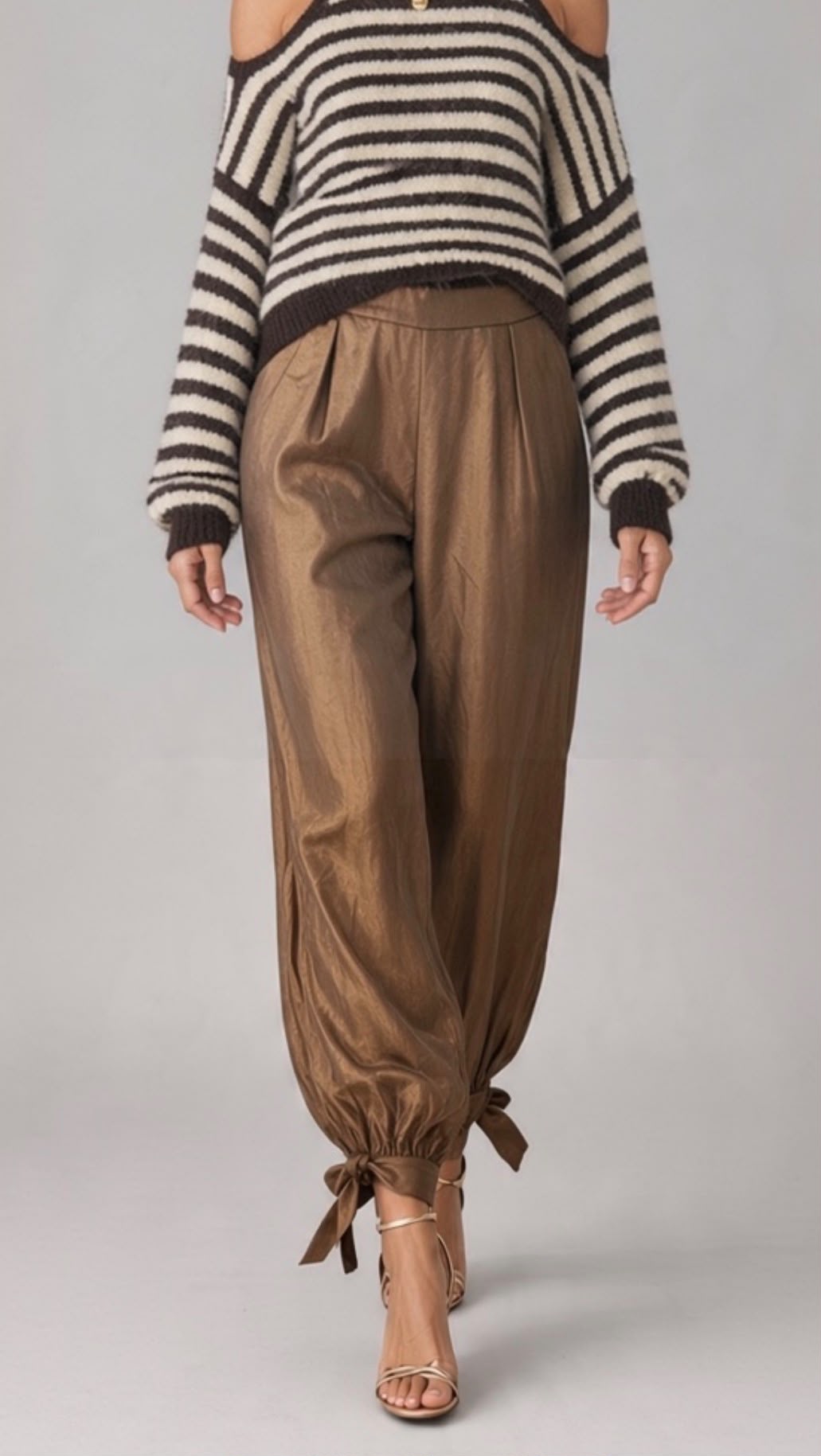 Chastar broek in Brons met lange pijpen en enkelstrikken, gecombineerd met een donkere gestreepte trui.