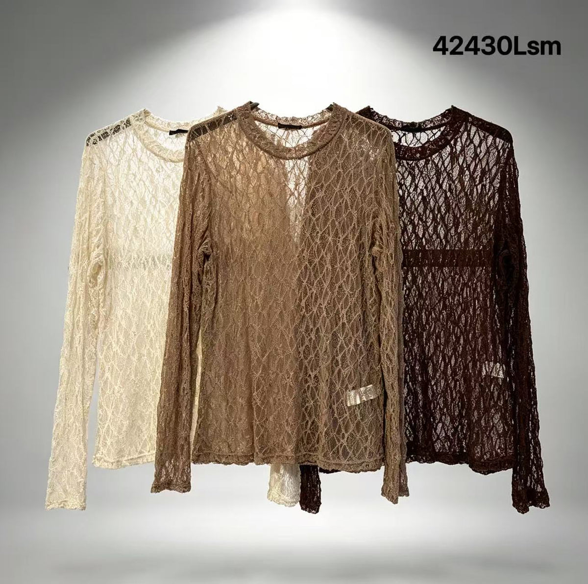 Chastar Top Amira in off white, camel en bruin met lange mouwen en een transparant opengewerkt motief, aan kledinghangers.